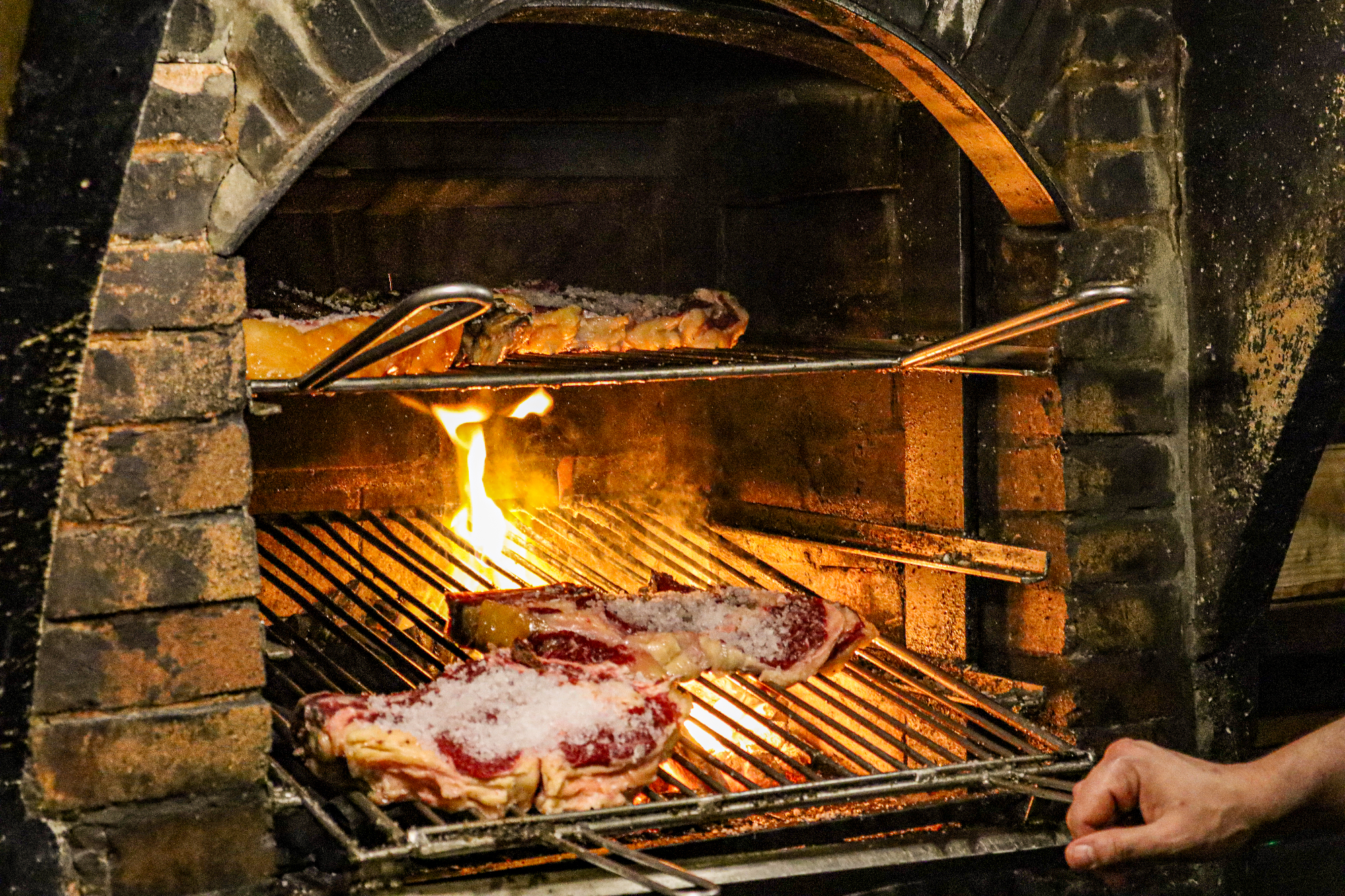 Grilling steaks over fire
