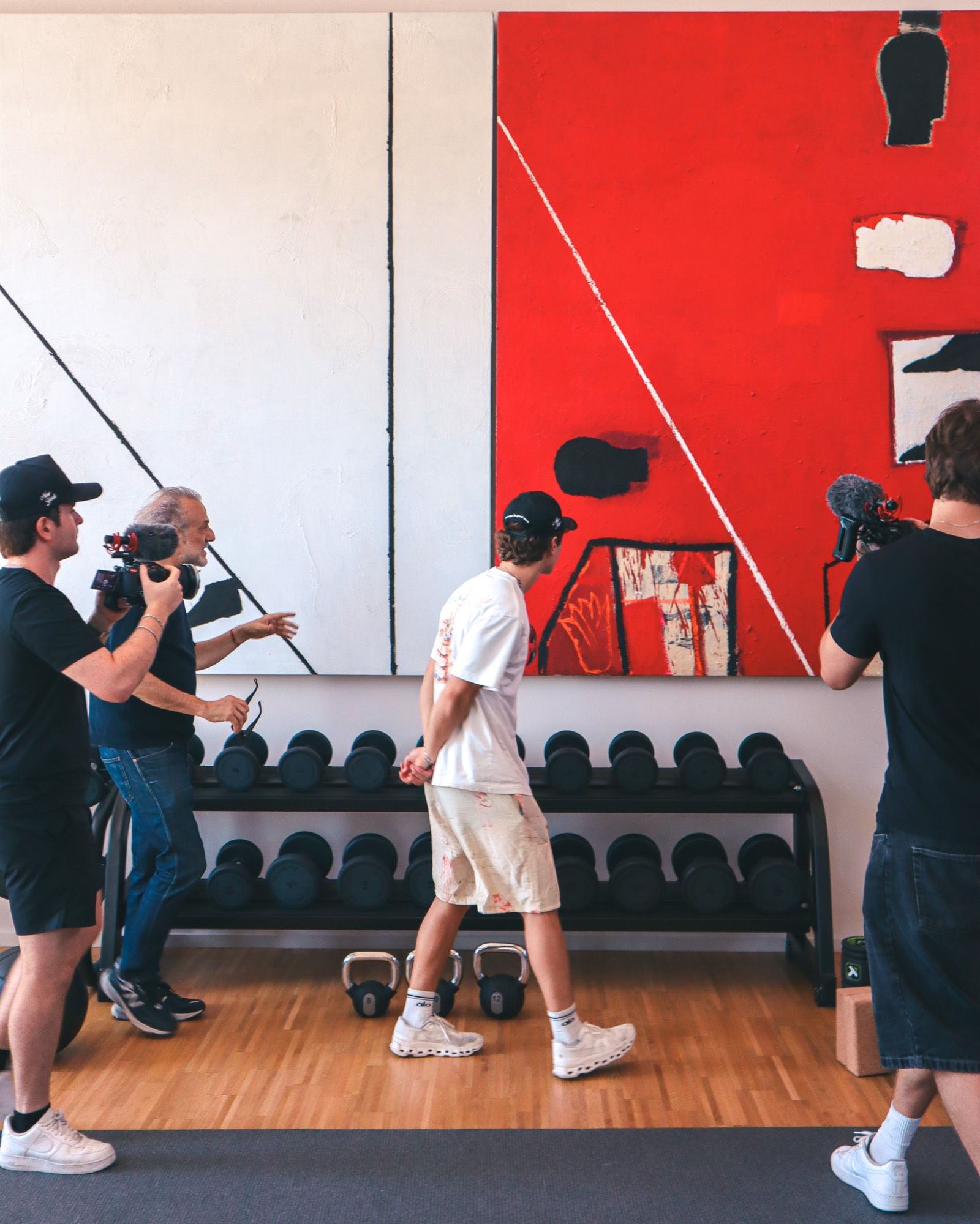 Film crew shooting in a home gallery with abstract paintings