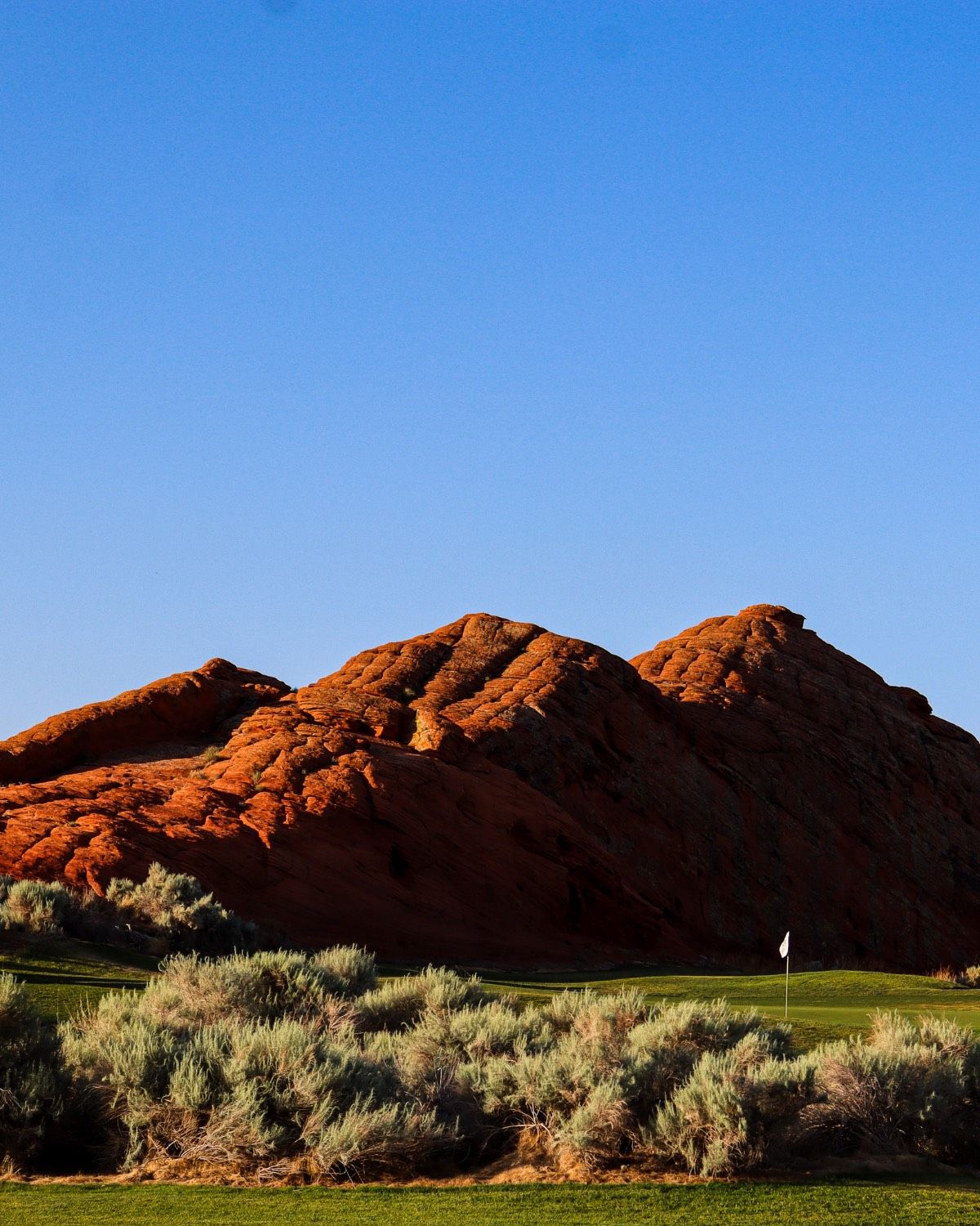 Red rock formation behind a golf course green