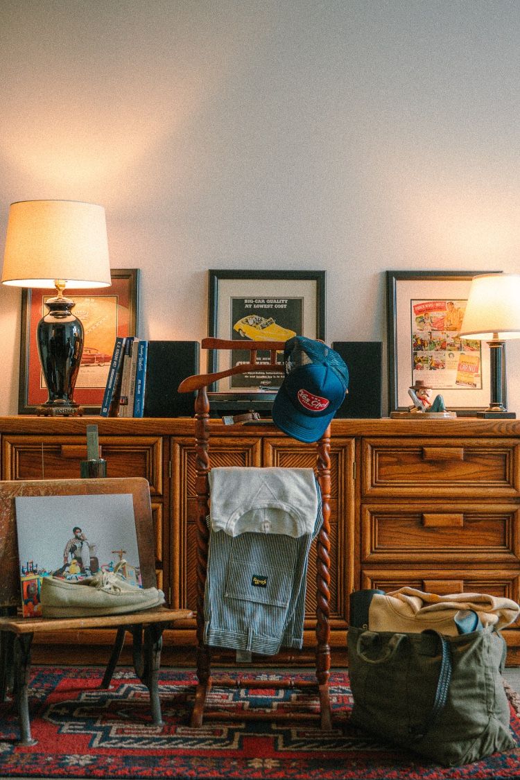 Striped pants and trucker hat styled on a vintage dresser